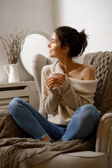 Woman relaxing in an armchair with a cup of tea